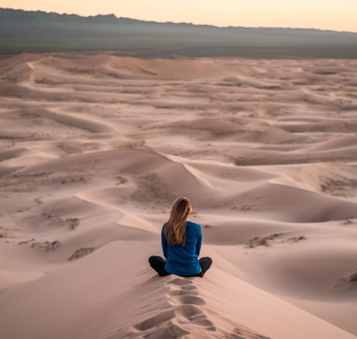 Woman meditating in desert
