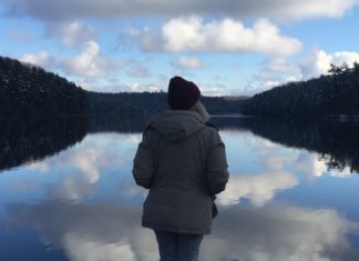 Girl standing in front of lake