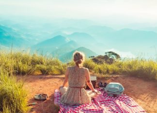Woman sitting on blanket at a viewpoint