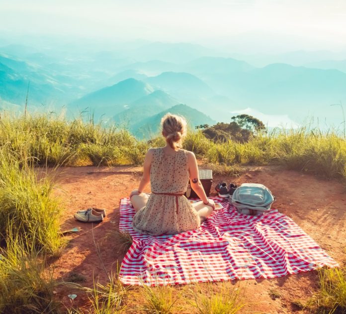 Woman sitting on blanket at a viewpoint