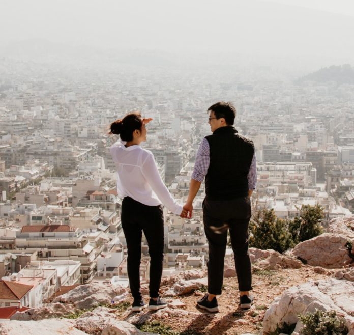 Couple on top of a mountain holding hands