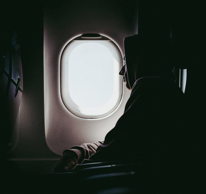 Man sleeping by plane window