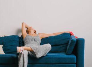 Woman sitting on sofa in jumpsuit