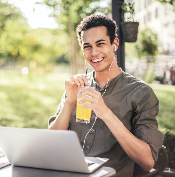 Man sitting with laptop and orange juice